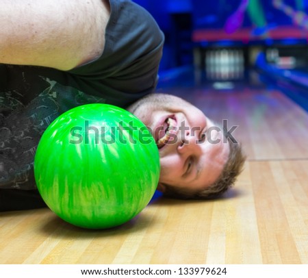 Bizarre drunk man lying on bowling alley