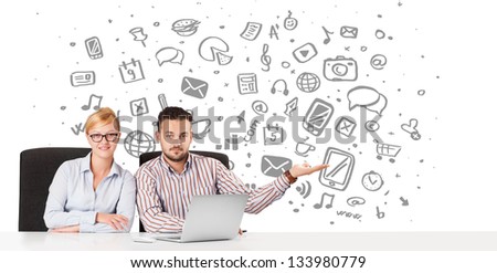 Young businessman and businesswoman with all kind of hand-drawn icons in background