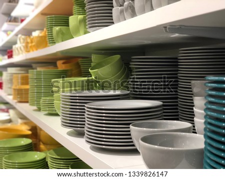 colorful porcelain plates and cups on the store shelf