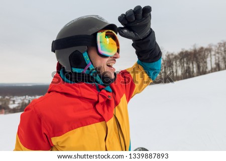 happy young sportsman sun glasses. close up side view photo, free time, spare time, guy is exploring the area for snowboading