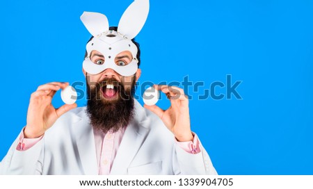 Happy Easter! Easter day. Spring holiday. Surprised bearded man holds white eggs. Egg hunt. Easter bunny. Easter concept. Man witn bunny ears. Bearded man. White eggs. Party.
