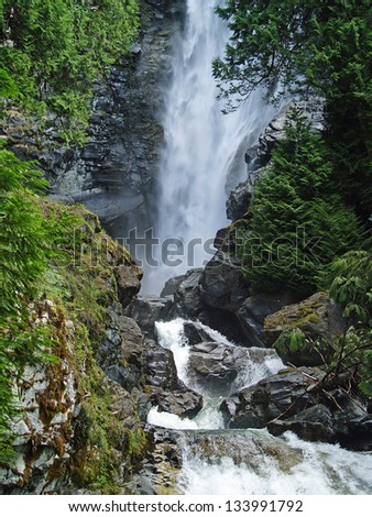 Beautiful Mountain Waterfall Surrounded by Wooded Wilderness