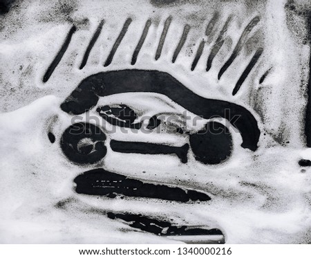 The passenger car is painted on white soap suds. Black background. Car wash concept.