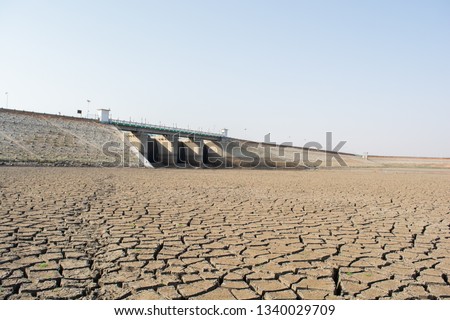 A dried up empty reservoir or dam during a summer heatwave, low rainfall and drought in north karnataka,India Royalty-Free Stock Photo #1340029709
