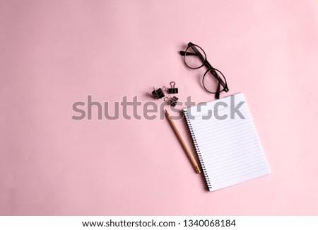 Notebook and pencil pasted on a pink background. Top view.