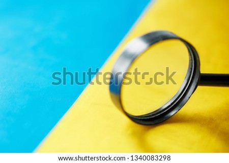 UKRAINE flag looking through a magnifying glass. The study of the history and culture of the people of the country of Ukraine. The concept of studying the geography, customs of Ukrainians, language