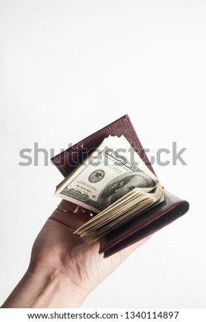 The concept of finance and savings, feng shui and financial well-being. Hand holds wallet with one hundred dollar bills.