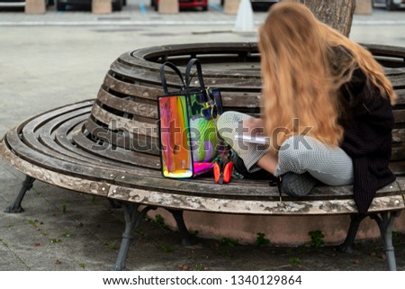 blurry blonde girl on a bench. long exposition