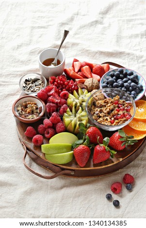 Healthy breakfast board included granola, fruits and berries selection, nuts and honey. Plant based, clean eating, super food, vegetarian concepts.