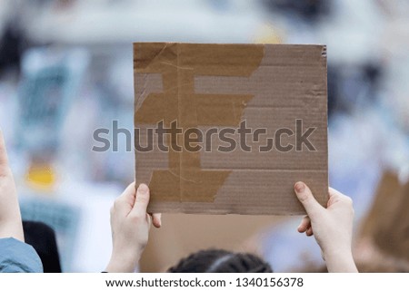 A protestor holding a blank placard at a political protest
