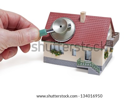 House diagnostics. Model house with hand and stethoscope on white background