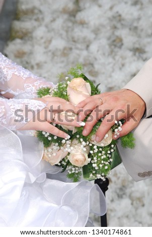 pictured in the photo Hands and rings on wedding bouquet