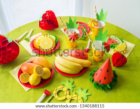 Decor for a holiday of children's birthday. Fruit party. Cake and sweet candy. Disposable tableware and tropical fruits. Watermelon and pineapple costume.