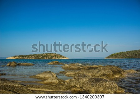 summer vacation and travel landscape photography of tropic rocky coast shoreline of Mediterranean shallow lagoon with view on lonely island in vivid clear weather time