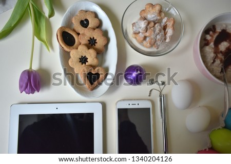 Spring background with purple tulip flowers, mobile smart pnone, feather, tablet and notebook, copy space. Top view. Woman's Day (March 8), Mother's Day , Easter.