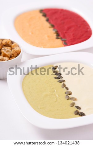 Different colored puree soups (cauliflower, pea, carrot and beet)