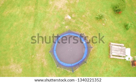 Aerial shot of the trampoline on the playground it is a big round area with screen on the side to prevent accidents