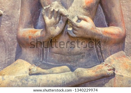 Ancient sandstone sculpture of Gautam Buddha in sitting posture (mudra) in meditation closeup macro view