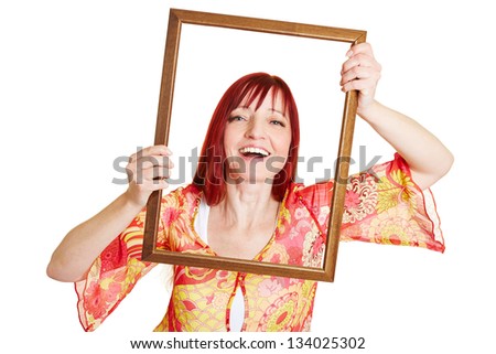 Happy best ager woman holding empty picture frame in front of her face