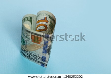 Win-win and commercial money investment profit concept. 100 US Dollars cash money bank note heart shape on blue background