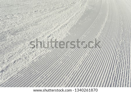 Close-up groomed snow ready for ski downhill