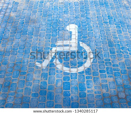 Top view on parking sign for disable people. Disabled parking space and wheelchair symbols on pavement.