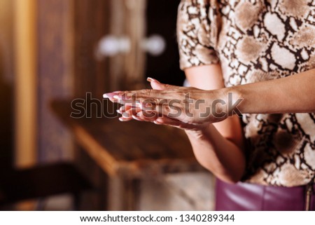 Close up photo of woman's hands applying hand cream. Skin care, body care, beauty products, spa, hair care concept.