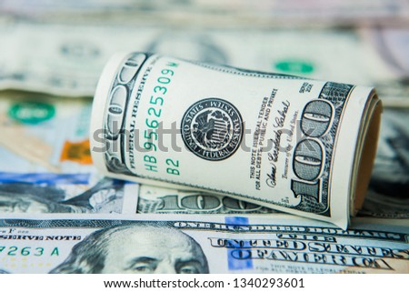 Close-up of stack of dollars against the backdrop of money.