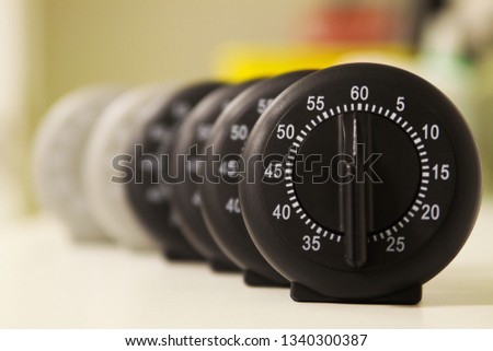 Time is slipping away concept: Close up of a group of analog stop watches in a row