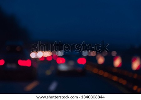 Defocused car lights in a darkness. Night road, city life. Colorful bokeh lights.