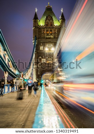 A image of Tower Bridge, London taken with a slow shutter speed. Pedestrians and traffic blur in the scene creating a sense of movement.