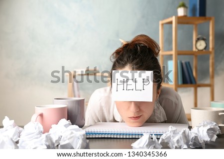 Young woman with note HELP on forehead at workplace. Space for text Royalty-Free Stock Photo #1340345366