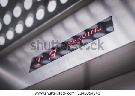 Red LED in a metallic elevator display showing the elevator going upward with modern design