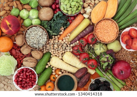 Health food for a high fibre diet concept with fruit, vegetables, whole grain bread, grains, legumes, nuts, grains, seeds, spirulina and cereals. Foods with antioxidants, anthocyanins & vitamins. Royalty-Free Stock Photo #1340414318