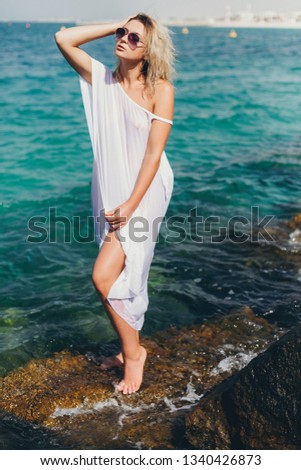 A young and stylish girl is having a rest in the resort of ha walking around the sea