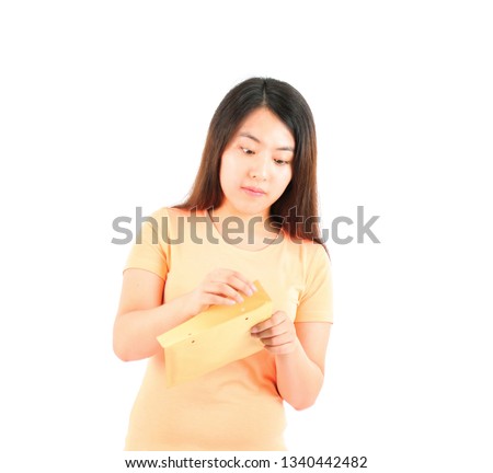 Intrigued young asian woman opening a brown envelope against a white background