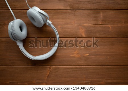 Wired headphones on wooden background.