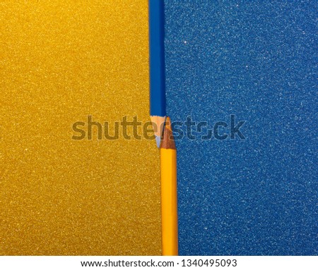 two pencils, blue and yellow on colored and brilliant cards placed contrasting the background, free space for text on both sides