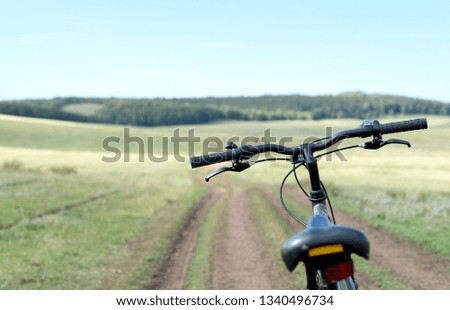 Single parked bike on a dirt road with a forest background and nobody in the travel scene