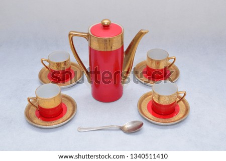 Mock up / design set of elegant and traditional colorful Red and gold traditional elegant coffee cup & Tea cup on cup's plate beside the hot tea jar container , design/ drink-ware