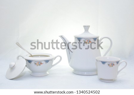 Mock up - design set of elegant and traditional teapot colorful white and blue coffee cup and Tea cup on cup's plate beside the hot tea pot , design - drink-ware isolated on white background