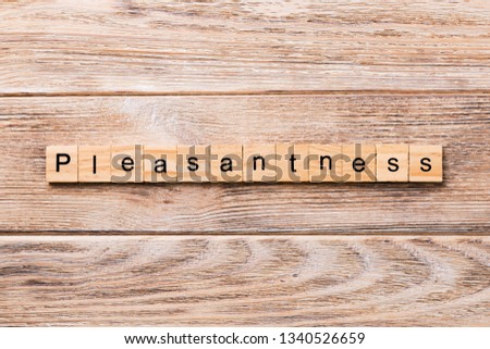 pleasantness word written on wood block. pleasantness text on wooden table for your desing, concept.
