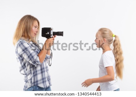 Photo, photographer and retro camera concept - young woman using vintage camera on white background