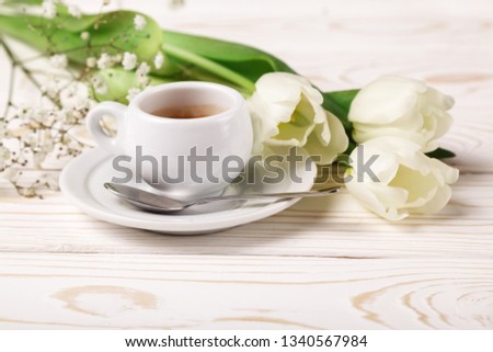 Spring tulips and coffee on a white wooden background close-up. Mother's day background, women's day, morning Birthday.