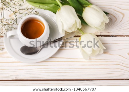 Spring tulips and coffee on a white wooden background, top view. Mother's day background, women's day, morning Birthday.
