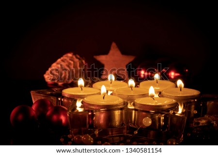 Christmas decoration on dark background, candles in a star of glass