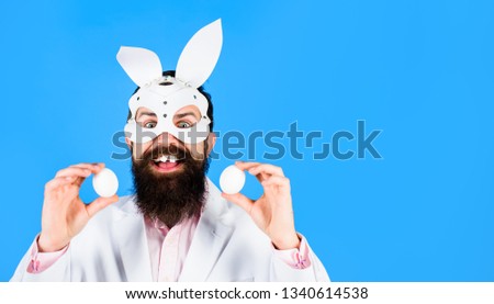 Happy Easter! Easter day. Spring holiday. Surprised bearded man holds white eggs. Egg hunt. Easter bunny. Man witn bunny ears. Bearded man. White eggs. Easter party. Rabbit mask.