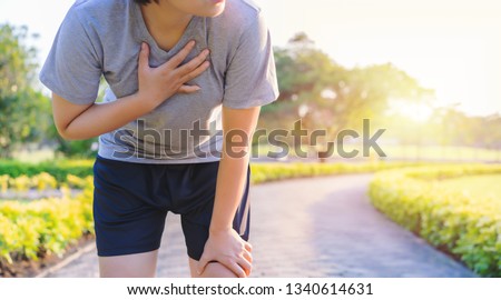 Woman have chest pain while running in the garden. Medical and healthcare concept Royalty-Free Stock Photo #1340614631