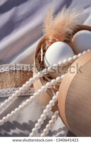 easter eggs with feathers and pearls in a box