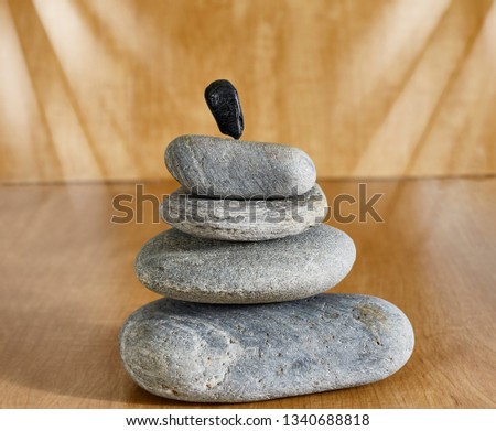River rocks balanced  on one another on wood with shallow depth of field